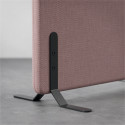 Närbild hörn av ljudabsorberande golvskärm i rosa klädsel, med svarta skärmfötter. Närbild hörn av ljudabsorberande golvskärm i rosa klädsel, med svarta skärmfötter.