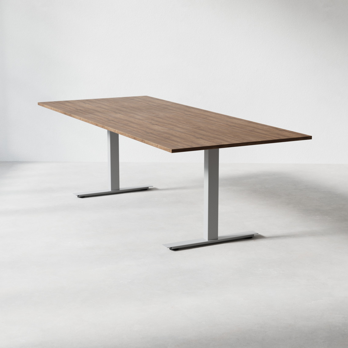 Konferensbord med valnötsfärgad laminatskiva 240x100 cm och silvrigt t-stativ.