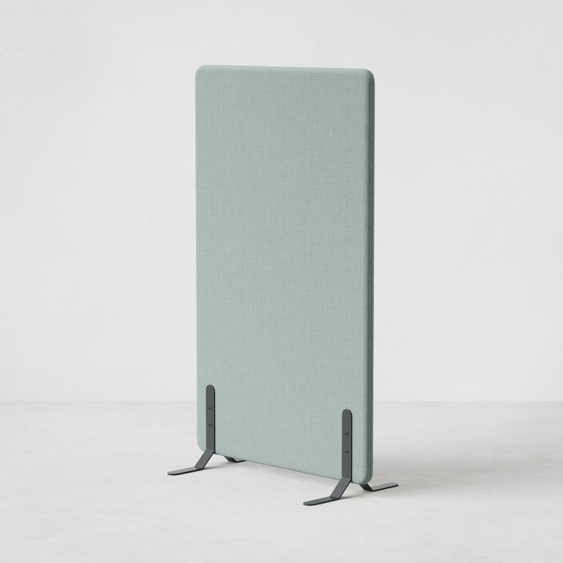 Ljudabsorberande golvskärm i grön klädsel utrustad med svarta skärmfötter, snett från sidan. Ljudabsorberande golvskärm i grön klädsel utrustad med svarta skärmfötter, snett från sidan.