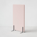 Ljudabsorberande golvskärm i rosa klädsel utrustad med svarta skärmfötter, snett från sidan.