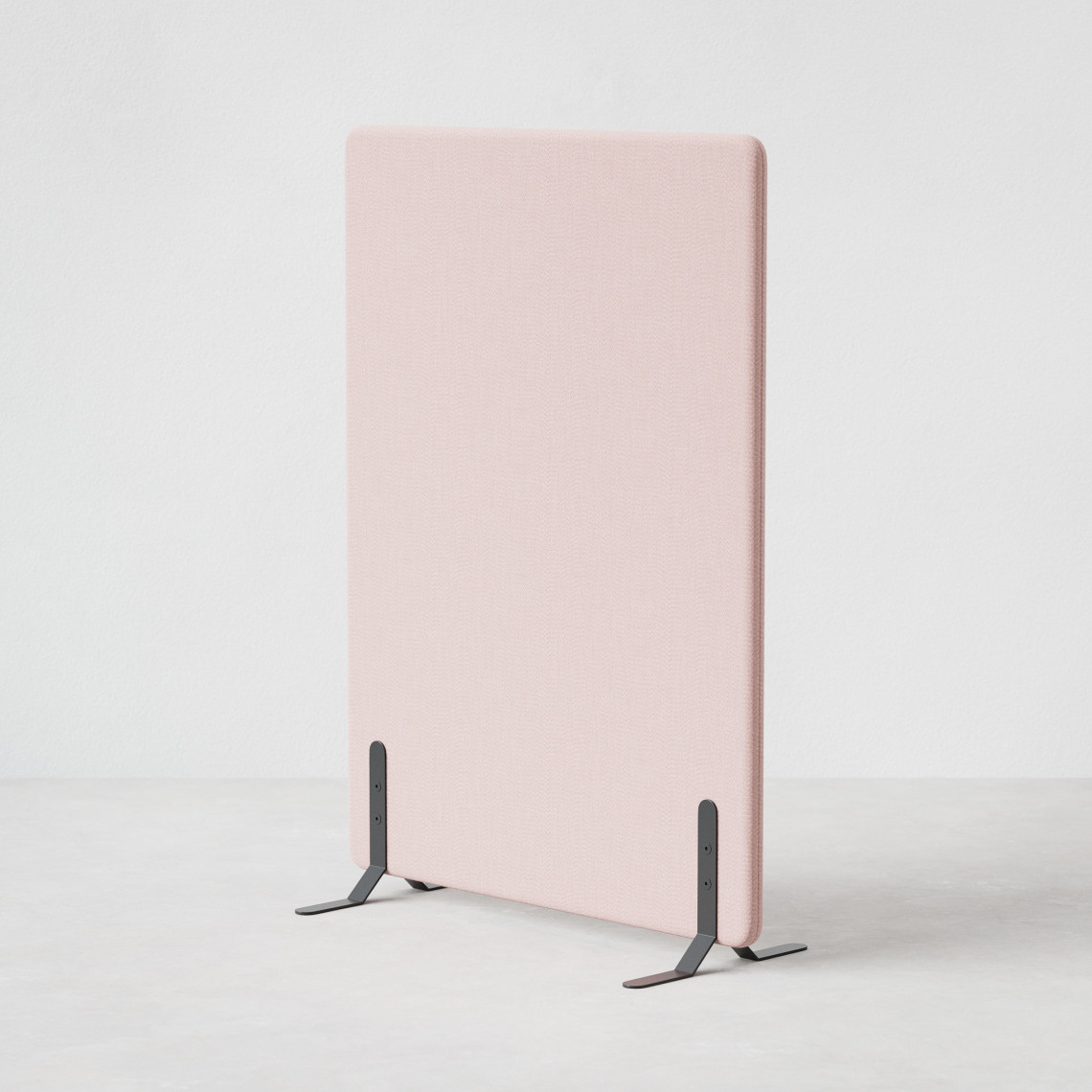 Ljudabsorberande golvskärm i rosa klädsel utrustad med svarta skärmfötter, snett från sidan.