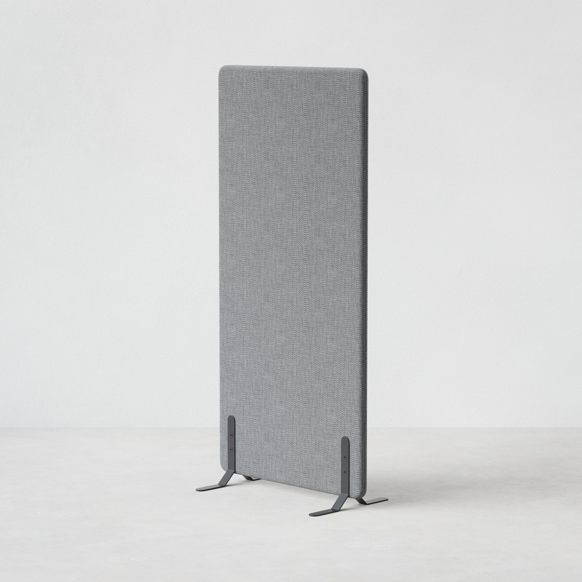 Ljudabsorberande golvskärm i grå klädsel utrustad med svarta skärmfötter, snett från sidan.