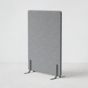 Ljudabsorberande golvskärm i grå klädsel utrustad med svarta skärmfötter, snett från sidan.