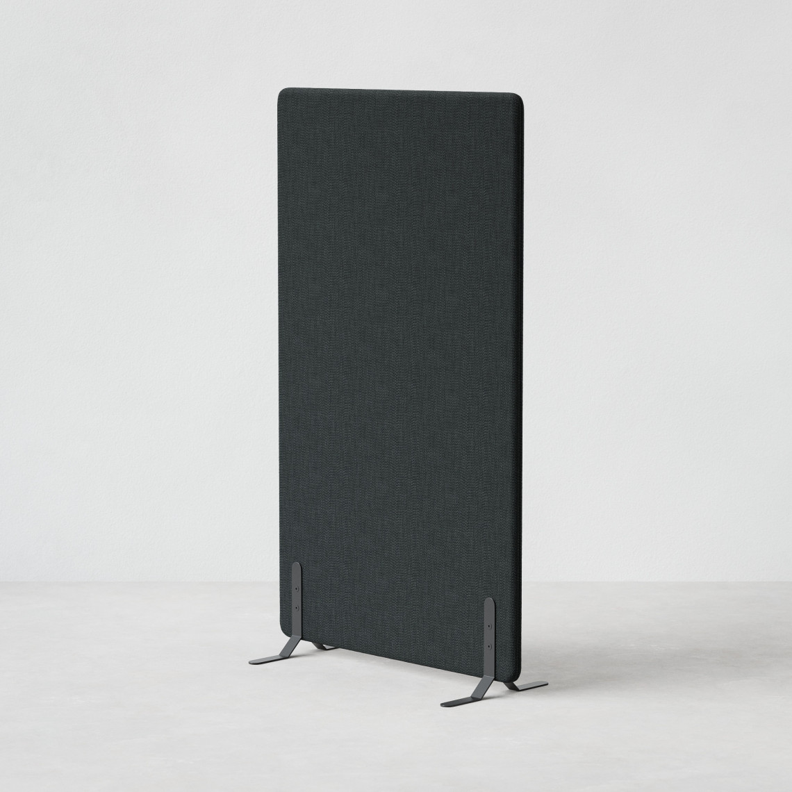 Ljudabsorberande golvskärm i svart klädsel utrustad med svarta skärmfötter, snett från sidan.