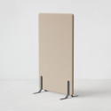 Ljudabsorberande golvskärm i beige klädsel utrustad med svarta skärmfötter, snett från sidan.