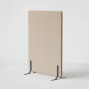 Ljudabsorberande golvskärm i beige klädsel utrustad med svarta skärmfötter, snett från sidan.