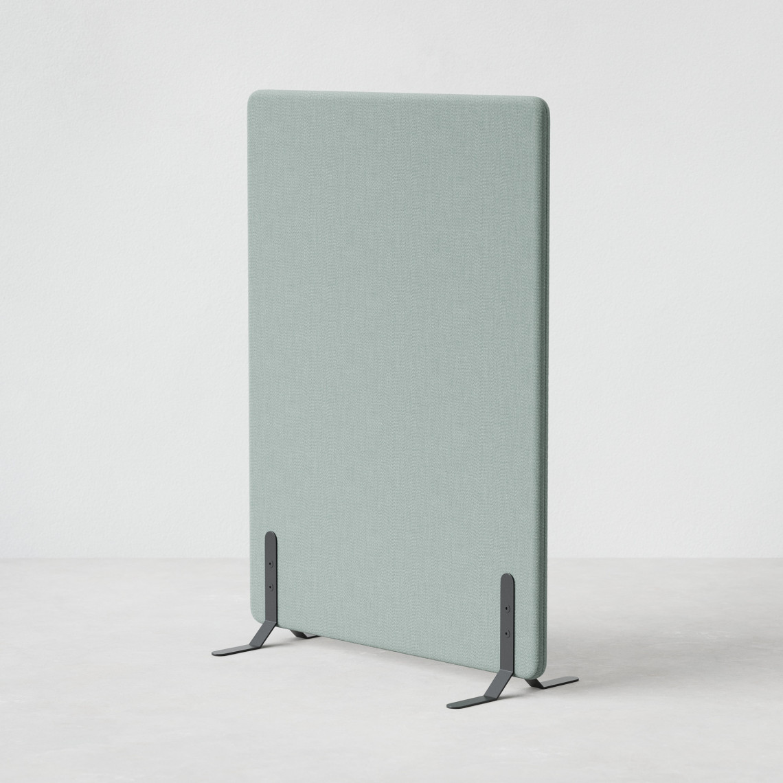Ljudabsorberande golvskärm i grön klädsel utrustad med svarta skärmfötter, snett från sidan.